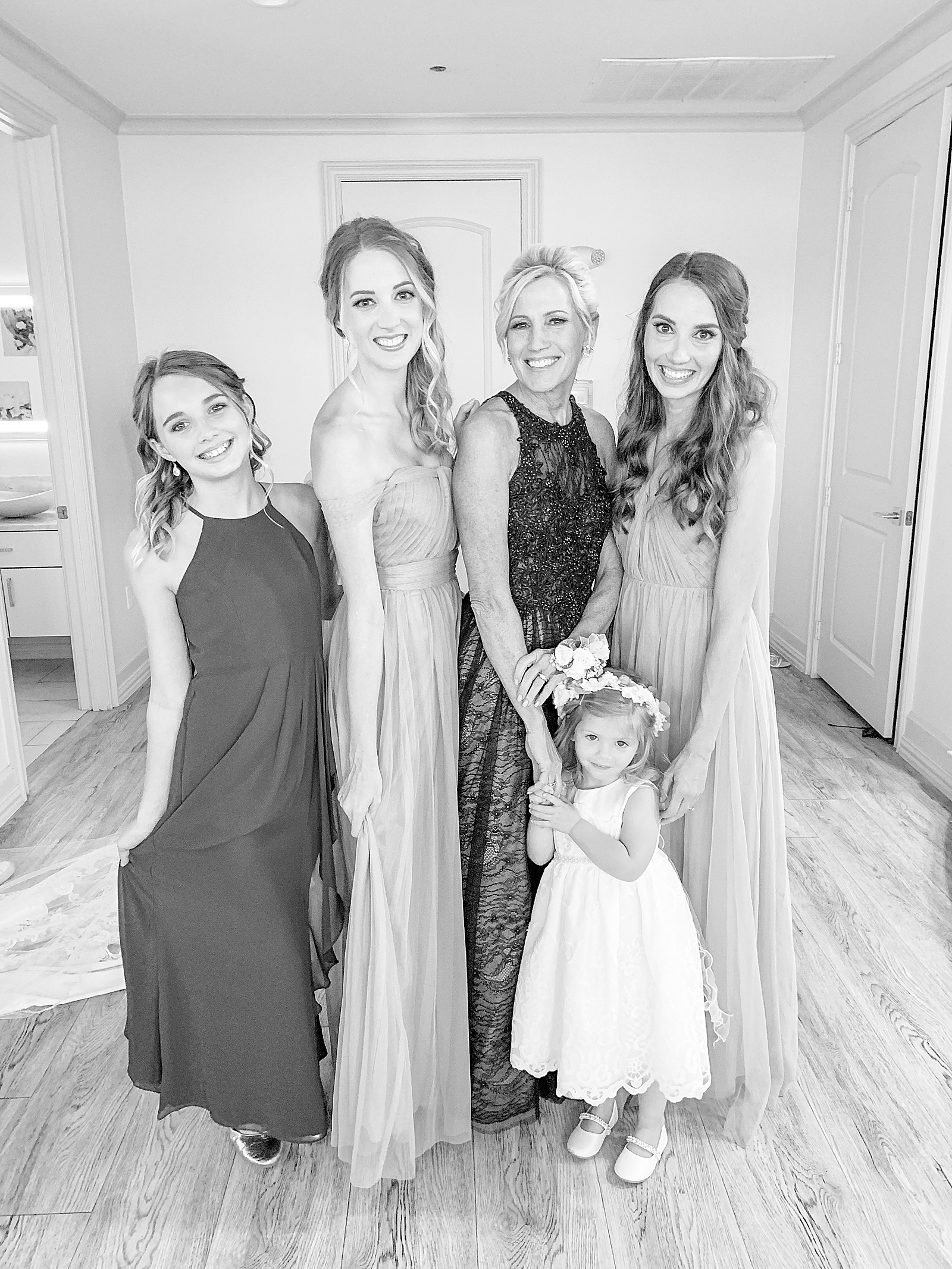 60th Birthday Black and White Picture of mom with 2 generations of girls all wearing dresses and smiling at the camera 
