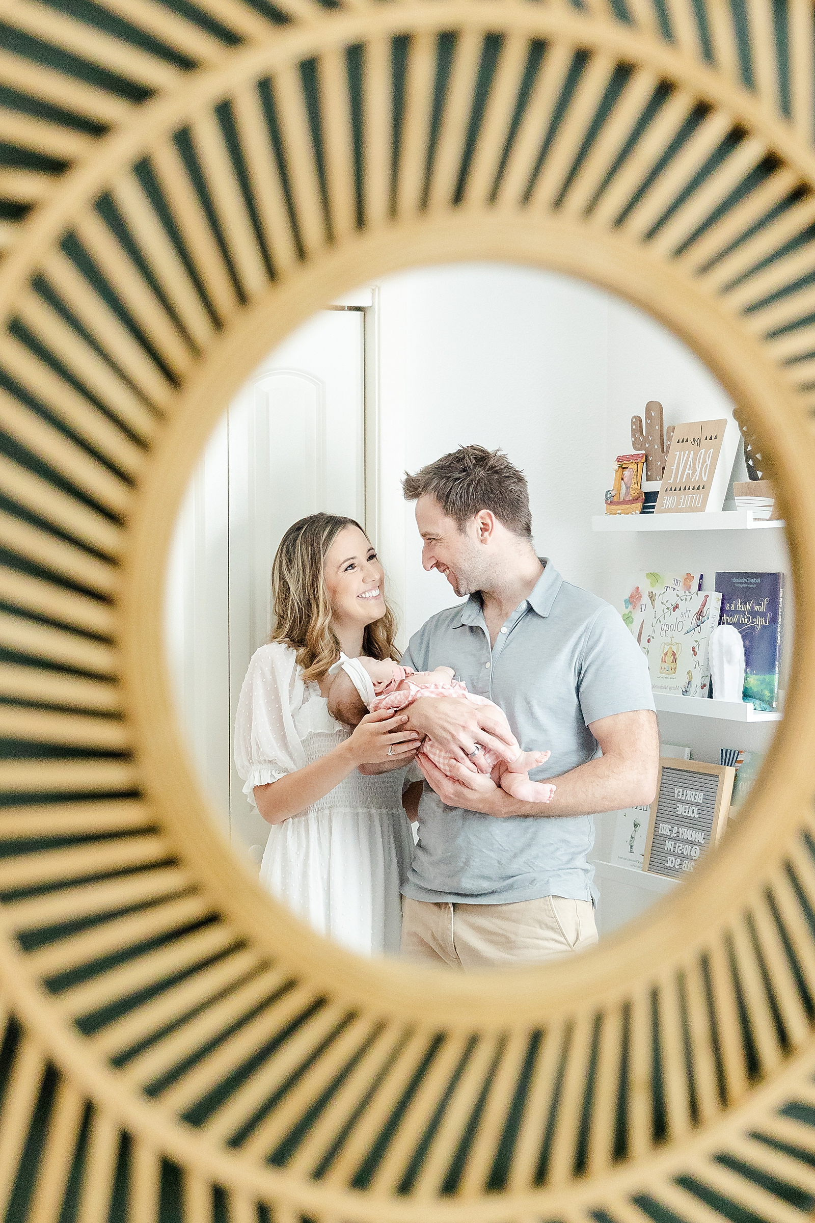 Lifestyle Newborn Photos picture of parents holding baby and smiling in the mirror